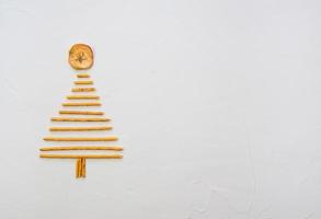 Kerstmis boom gemaakt van pepero rietjes koekjes, Aan wit achtergrond textuur. top visie met ruimte voor tekst Aan de Rechtsaf foto