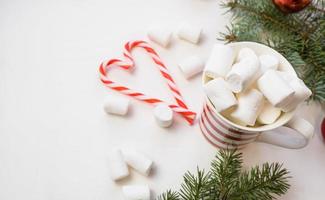 traditioneel heet chocola met marshmallows en lolly Aan een wit getextureerde achtergrond. Kerstmis drinken thema. foto