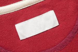 blanco wit wasserij zorg kleren etiket Aan rood kleding stof structuur achtergrond foto