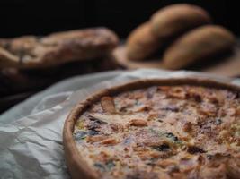 huis gemaakt Zalm Quiche Aan een hout tafel met mooi licht voor achtergrond foto