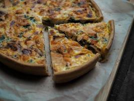 huis gemaakt Zalm Quiche Aan een hout tafel met mooi licht voor achtergrond foto