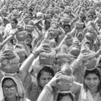 Delhi, Indië april 03 2022 - Dames met kalash Aan hoofd gedurende jagannath tempel mangal kalash jatra, Indisch Hindoe toegewijden dragen aarden potten met heilig water met kokosnoot Aan top-zwart en wit foto