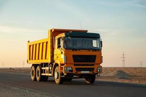 een oranje dump vrachtauto Aan de weg in de woestijn foto