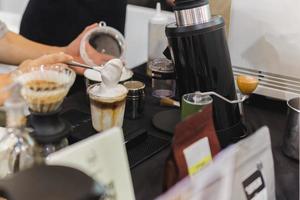barista maken bevroren latte koffie met hand- bekroond zweepslagen in cafe. foto