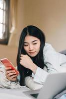 jong volwassen single vrouw gebruik makend van smartphone in de morgen voor sociaal bericht app babbelen met vriend foto