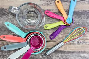 reeks van meten kopjes, meten lepels, meten glas en siliconen vliegenmepper gebruik in Koken leggen Aan houten tafelblad in top visie foto