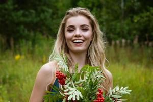 portret van een mooi vrouw met een boeket van lijsterbes foto