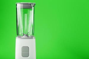 elektrisch blender met een leeg kruik Aan een groen achtergrond. foto