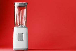 elektrisch blender met een leeg kop Aan een rood achtergrond. foto