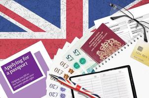 Engels paars gids toepassen voor een paspoort leugens Aan tafel met kantoor artikelen. uk paspoort papierwerk foto