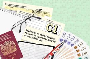 Engels het formulier c1 toepassing voor Verenigde koninkrijk paspoort voor aanvragers oud 16 of over- leugens Aan tafel met kantoor artikelen. uk paspoort papierwerk foto