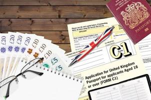 Engels het formulier c1 toepassing voor Verenigde koninkrijk paspoort voor aanvragers oud 16 of over- leugens Aan tafel met kantoor artikelen. uk paspoort papierwerk foto