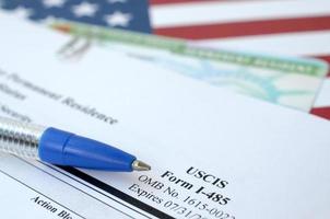 i-485 toepassing naar registreren blijvend residentie of aanpassen toestand het formulier en groen kaart van DV loterij leugens Aan Verenigde staten vlag met blauw pen van afdeling van thuisland veiligheid foto