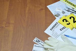 papierwerk gedurende misdrijf tafereel onderzoek werkwijze in csi laboratorium. bewijs etiketten met vingerafdruk aanvrager en rubber handschoenen Aan vooden tafel foto