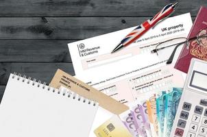 Engels belasting het formulier sa105 uk eigendom van hm omzet en douane leugens Aan tafel met kantoor artikelen. hmrc papierwerk en belasting betalen werkwijze in Verenigde koninkrijk foto
