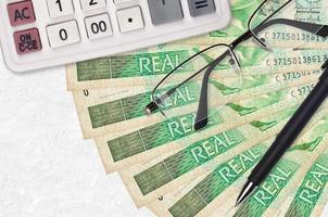 1 braziliaans echt rekeningen ventilator en rekenmachine met bril en pen. bedrijf lening of belasting betaling seizoen concept foto