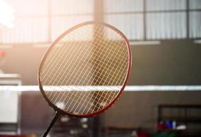 detailopname badminton racket in voorkant van de netto voordat portie het naar een ander kant van de rechtbank, zacht en selectief focus. foto