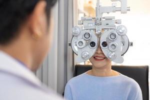 selectief focus Bij optometrie kader apparatuur. terwijl dokter gebruik makend van zaklamp en subjectief breking naar onderzoeken oog zichtbaar systeem van ouderling geduldig Dames met professioneel machine voordat gemaakt bril. foto