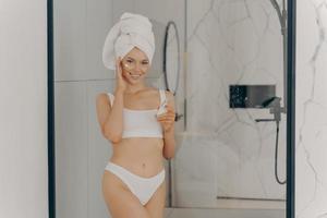 jonge dame geniet van ochtend anti-age anti-rimpel routine in de badkamer foto