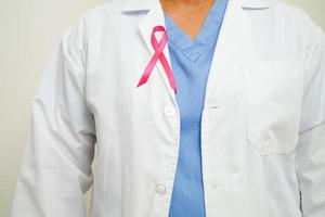 Aziatisch vrouw dokter met roze lint, wereld borst kanker dag Bij oktober. foto