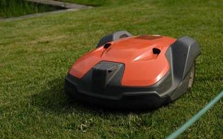 robot gazon maaier Aan groen gras achtergrond.automatisch robot grasmaaier in modern tuin.groen gras trimmen met gazon maaier. detailopname visie van de gazon maaier vuil blad na gras maaien de gazon. foto