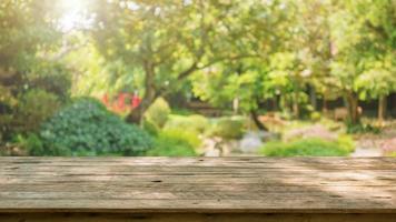 leeg hout tafel top met abstract vervagen park tuin vijver achtergrond foto