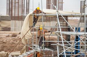 een arbeiders met speciaal uitrusting in een bouw plaats maken bekisting foto