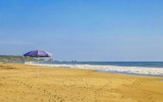 Purper parasol in de wind Bij strand puerto escondido Mexico. foto