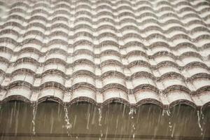 regen vallend naar beneden van de huis dak foto