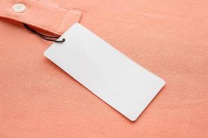 blanco wit kleren label etiket Aan roze kleding stof structuur achtergrond foto