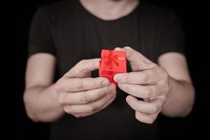 man geeft een cadeau in rode geschenkdoos op st. Valentijnsdag foto