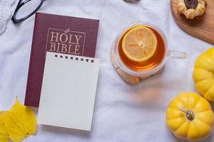 heilig Bijbel en blanco vel papier met herfst knus decor top visie. foto