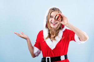 detailopname van Kaukasisch gelukkig vrouw vervelend de kerstman kleren lachend Holding Kerstmis bal foto