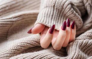 handen van een jong vrouw met donker rood manicure Aan nagels foto