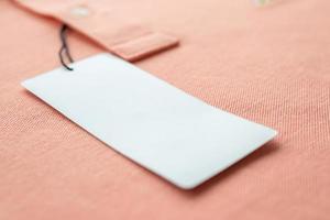 blanco wit kleren label etiket Aan roze kleding stof structuur achtergrond foto