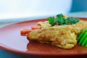 gevuld omelet, omelet met groente salade en hartvormig wortel, Aan blauw oud houten foto