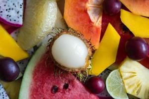 gemengd rijp en vers fruit detailopname voor kleurrijk achtergrond. draak fruit, ananas, papaja, limoen, mango, pompelmoes, ramboetan, pruim, watermeloen. foto