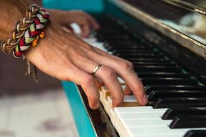 de handen van een jong Mens spelen piano Aan een straat van stad. foto