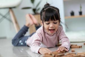 Aziatisch broer of zus meisje spelen houten stapels Bij huis foto