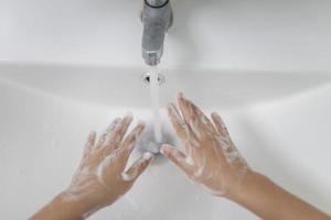 weinig Aziatisch meisjes wassen hun handen in de badkamer. zacht focus. kopiëren ruimte. foto