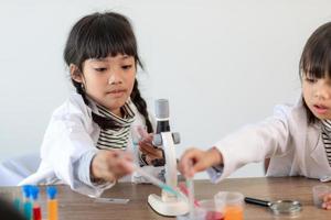 opleiding, wetenschap, chemie en kinderen concept - kinderen of studenten met test buis maken experiment Bij school- laboratorium foto