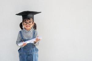 gelukkig Aziatisch school- kind afstuderen in diploma uitreiking pet foto