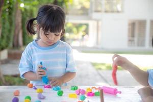 Aziatische kinderen spelen met kleivormende vormen, leren door te spelen foto