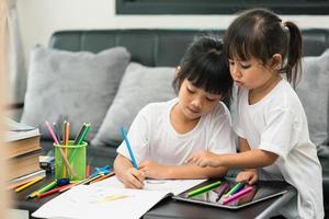 covid-19 coronavirus en leren vanuit huis, thuisschoolconcept. kleine kinderen studeren online leren vanuit huis met laptop. foto