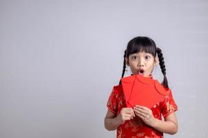 gelukkig Chinese nieuw jaar. glimlachen Aziatisch weinig meisjes Holding rood envelop foto