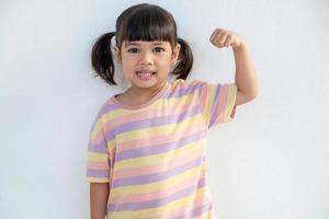 gelukkige Aziatische kinderen die haar sterke handen tonen foto