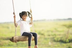 weinig meisje is swinging Bij Speel grond foto