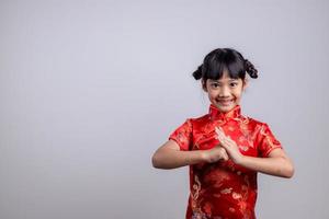 gelukkig Chinese nieuw jaar. weinig Aziatisch meisjes met felicitatie gebaar foto