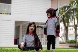 twee meisjes in de park met halloween kostuums, hebben pret foto