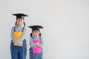 broers en zussen kinderen meisje diploma uitreiking met pet foto
